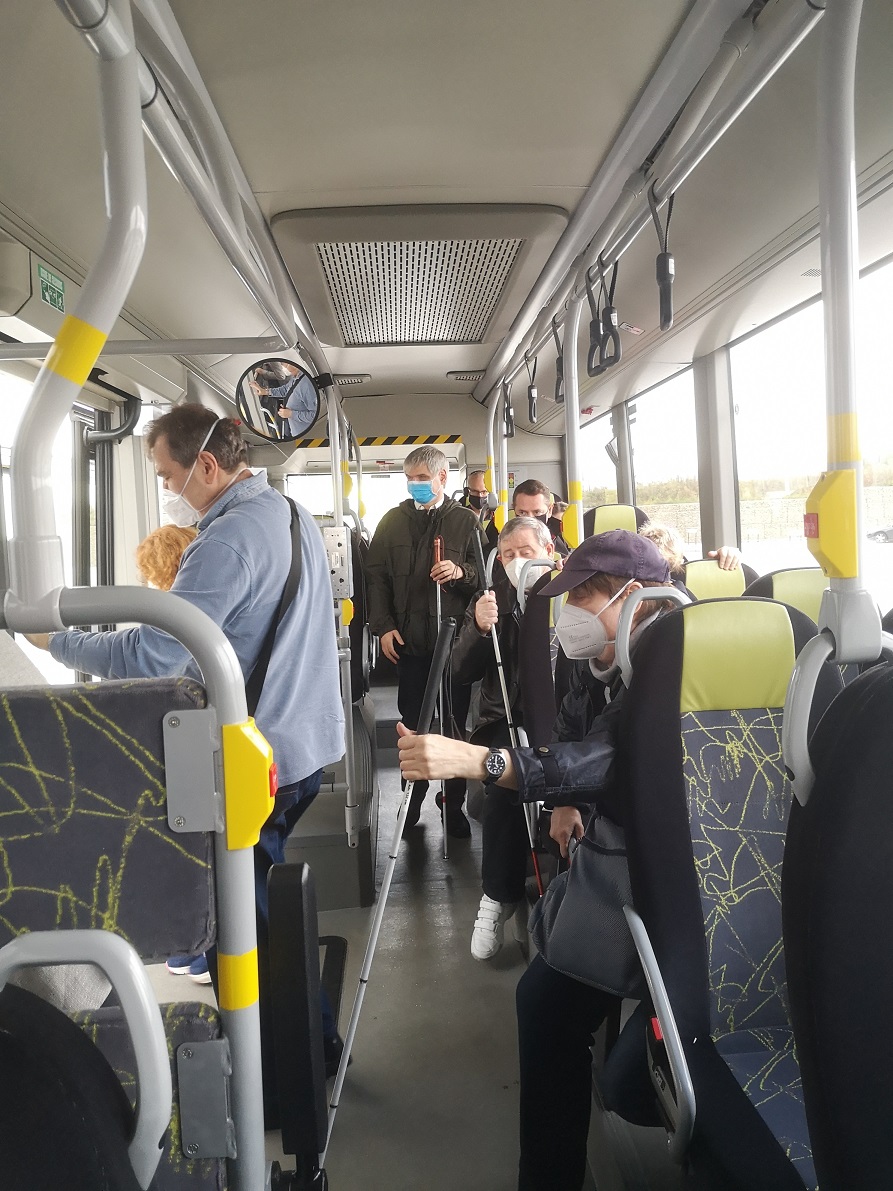 A mixed group of participants, some with white canes, travelling on the bus (Photo Romain Ferretti)